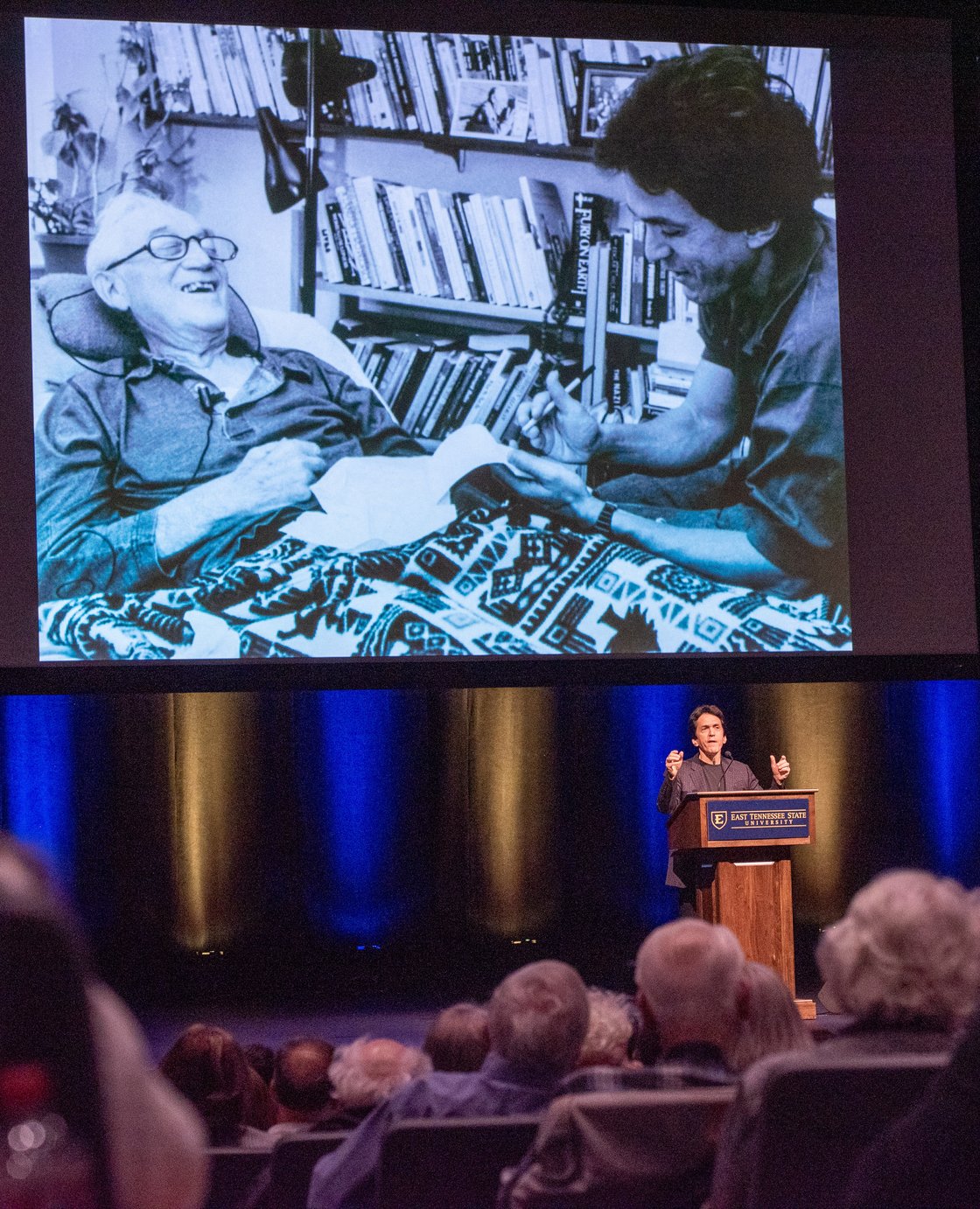 Mitch Albom, displaying a photo of Morrie in the background, speaks to large crowd at the ETSU Martin Center for the Arts.