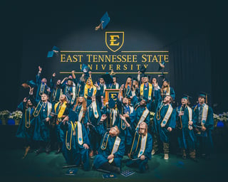 Members of ETSU's BlueSky Tennessee Institute inaugural class throw their caps in the air at graduation