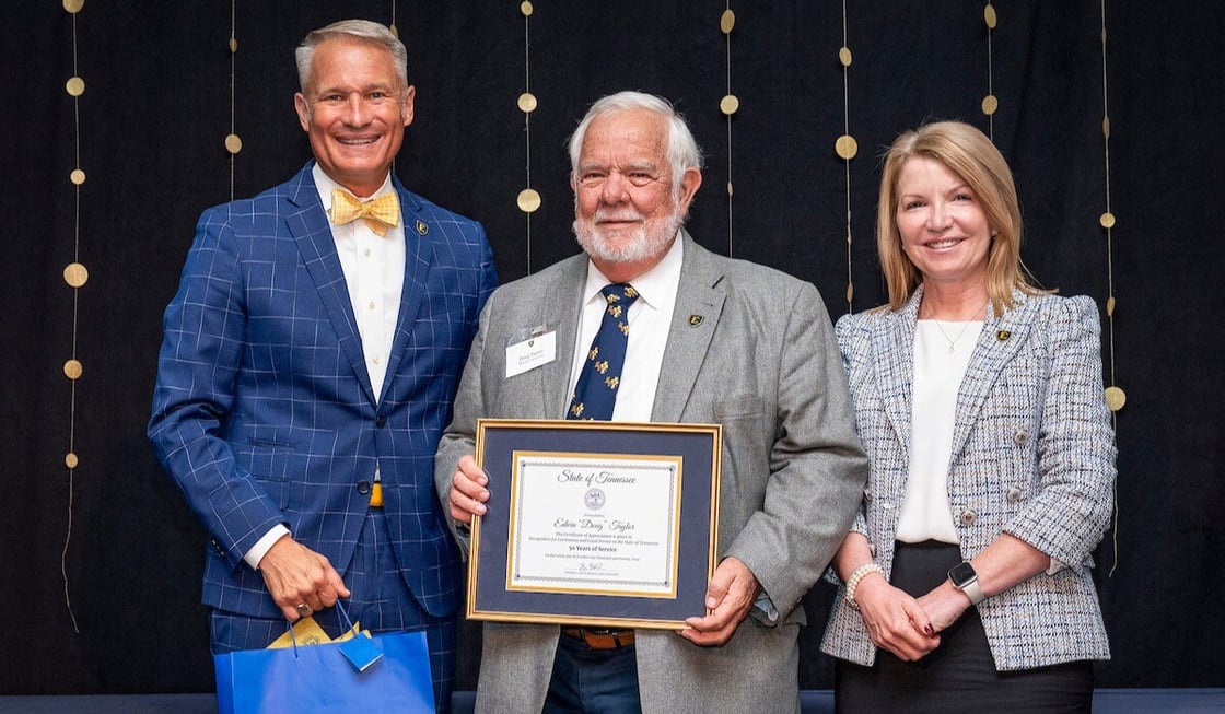 President Brian Noland and Provost McCorkle pose for a photograph with Doug Taylor. Doug holds a certificate celebrating his fifty years of service to the university. 
