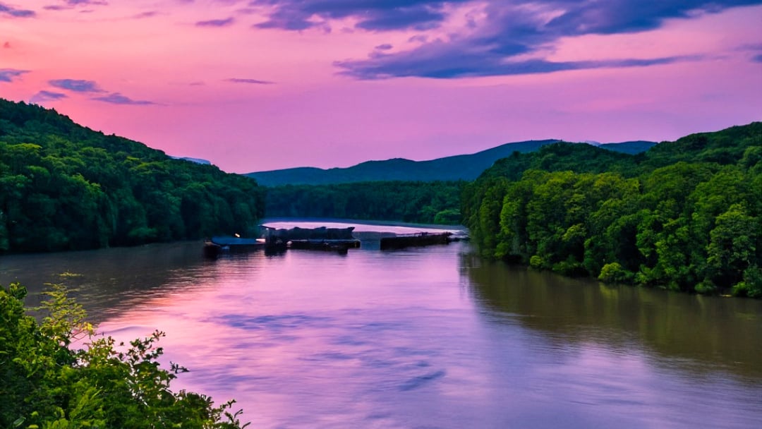 The lower Nolichucky river at sunset. The river reflects the  bright pink and blue sky. 