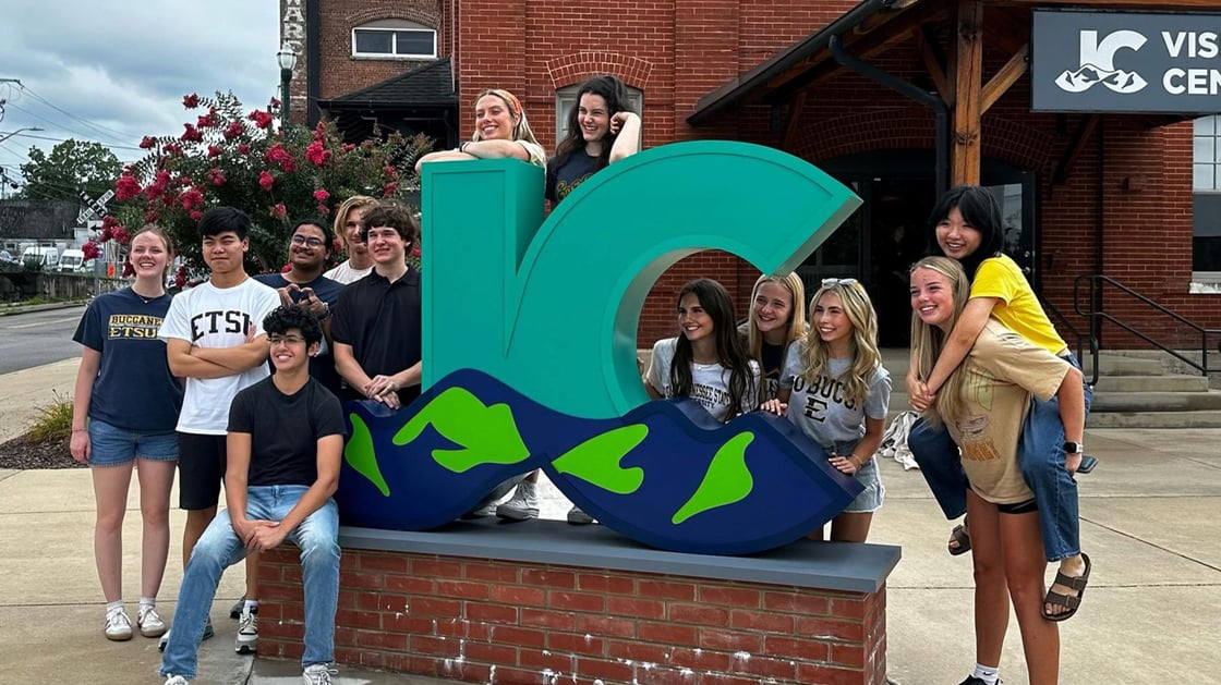 Roan Scholars pose beside the JC sign downtown. 