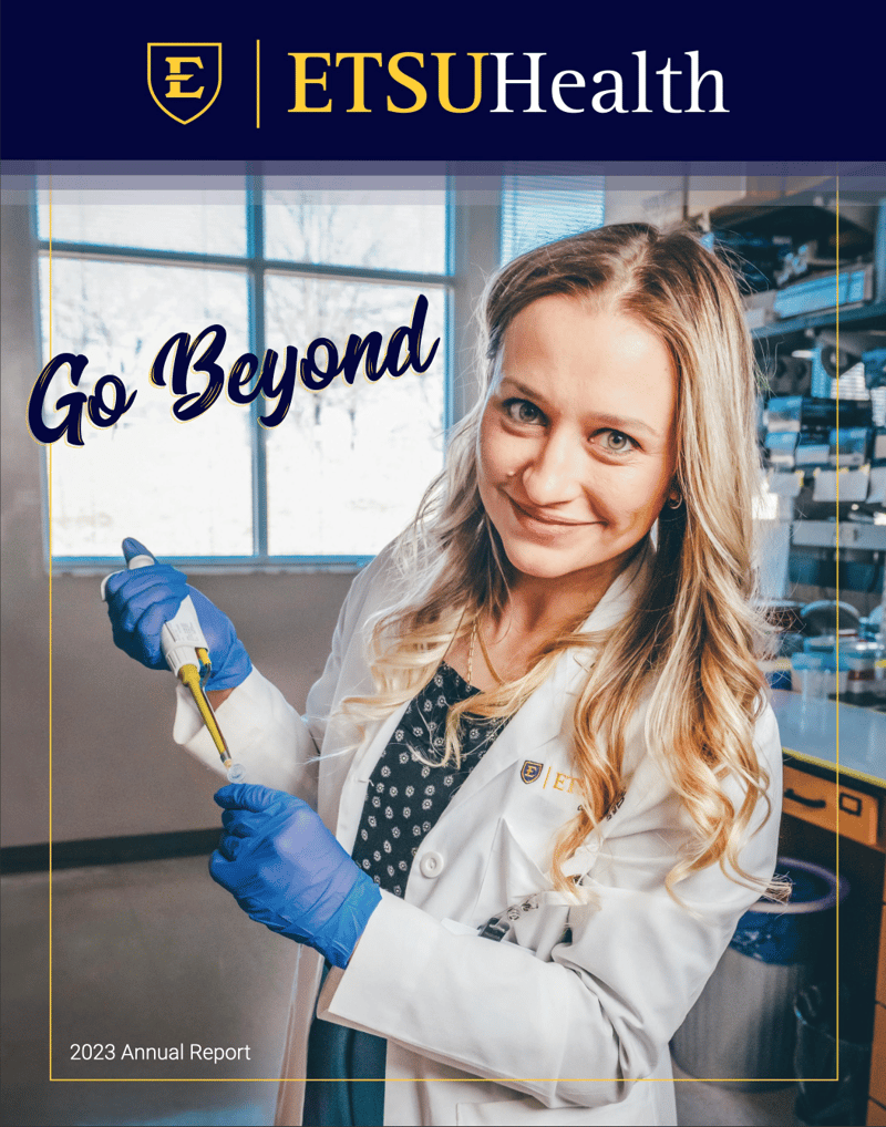The cover of ETSU Health magazine, featuring an ETSU health sciences student in a lab coat in a research lab. 