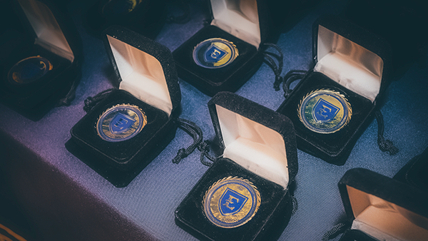 A line of gold medallions with the ETSU logo engraved on them.